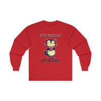 Red long-sleeve Valentine's shirt featuring an adorable cat-themed design. The front showcases a cute black and white cartoon cat with rosy cheeks, holding a red heart and smiling sweetly. Above and below the cat, playful text reads "IT'S MEOW OR NEVER" in a fun, romantic font. This cat lovers' shirt is perfect for Valentine's Day, offering a charming and lighthearted way to celebrate love and affection with a feline twist.